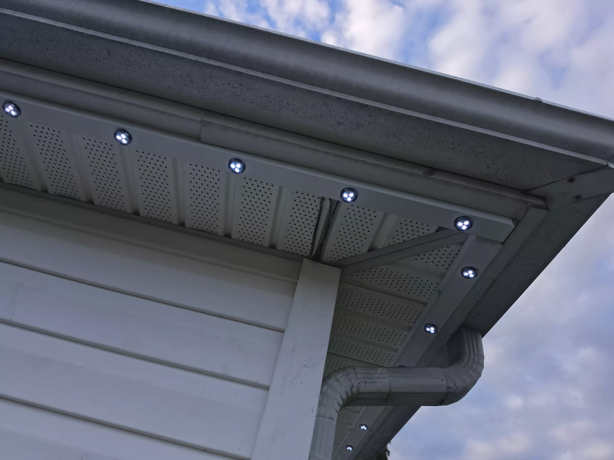 Low-profile lights set into a white soffit in daylight