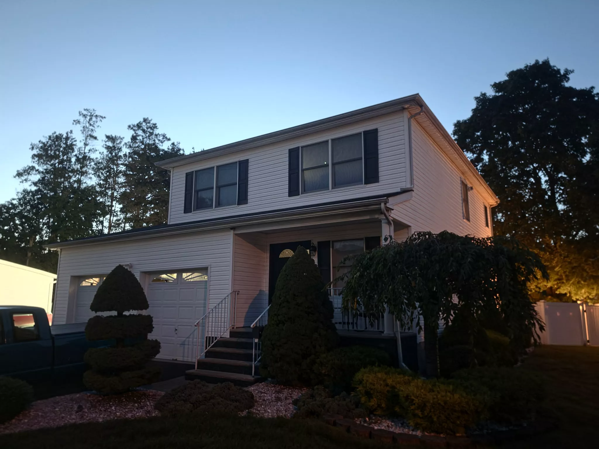 Two-story home at dusk with a porch light on