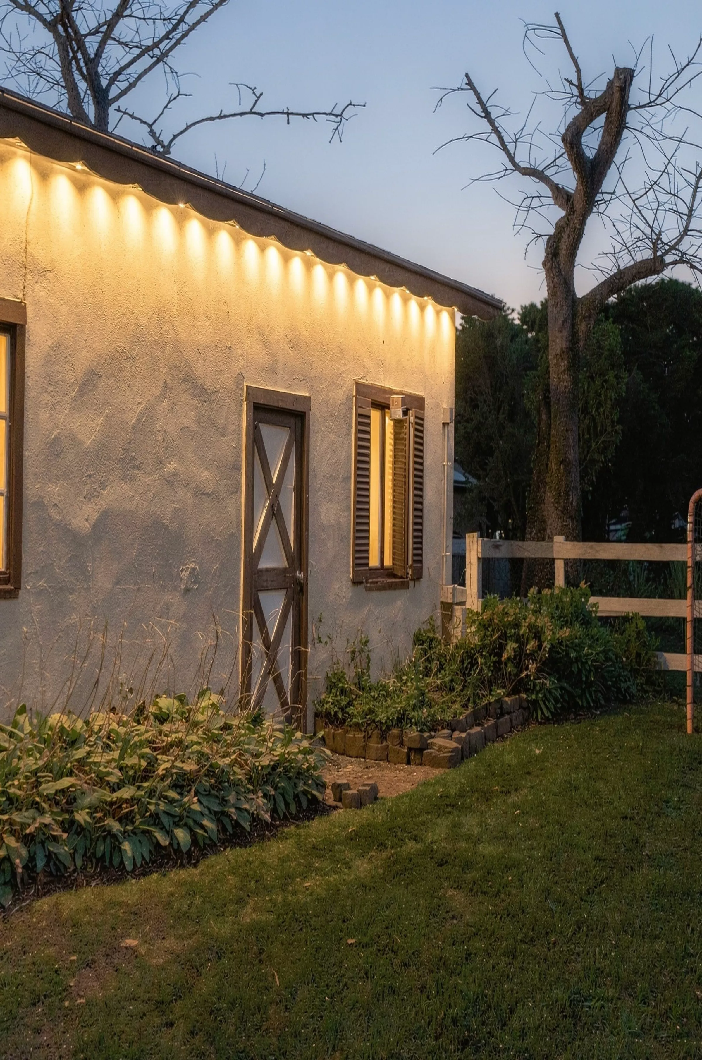 Barn wall glowing under warm white eave lights